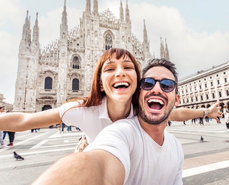 happy couple posing in front of cathedral on vacation