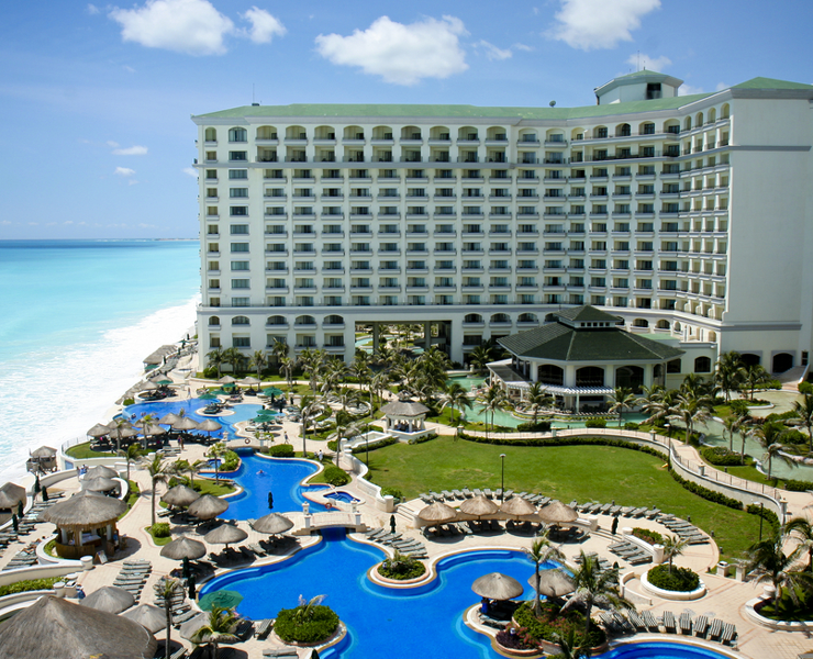 aerial view of hotel property oceanside with pool